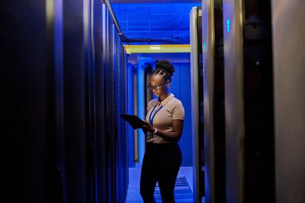 Female IT engineer using a digital tablet in a server room